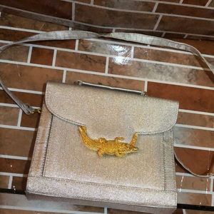 Shinny silver purse with a gold alligator 🐊
